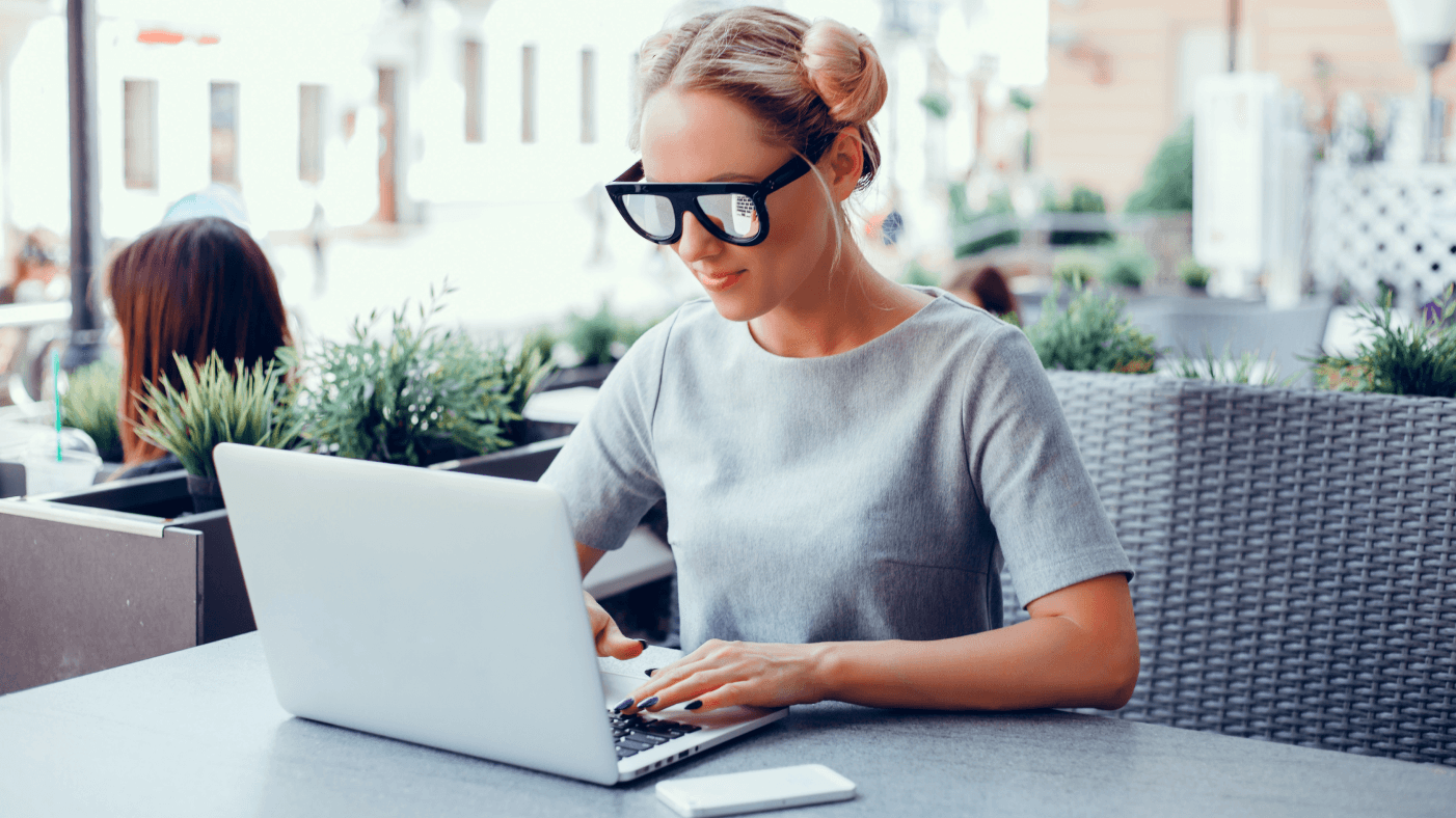 Girl with sunglasses working on a computer