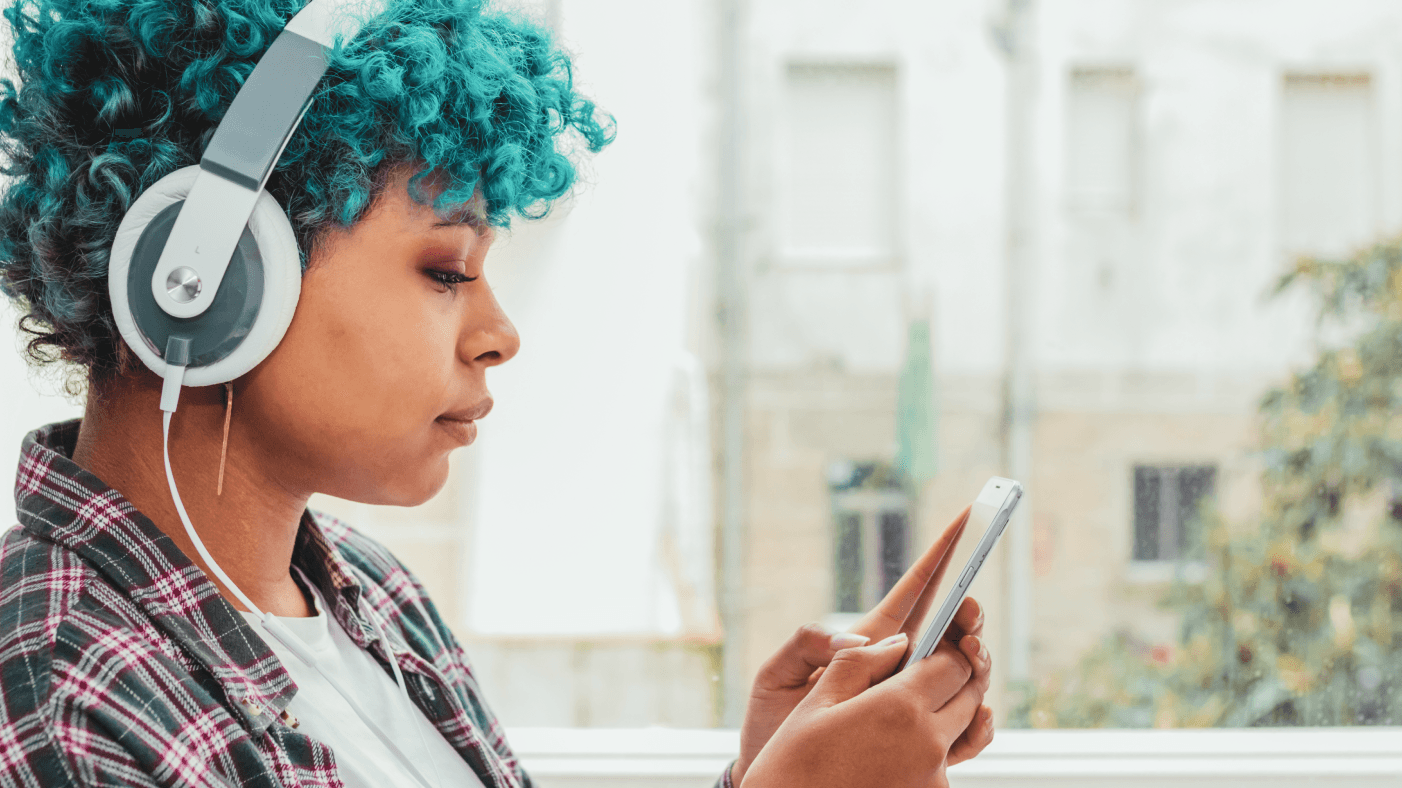 Girl with headphones scrolling through her mobile phone