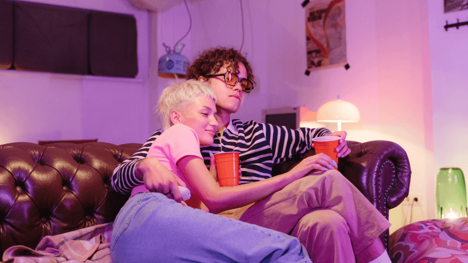 Mladi par sjedi na kauči i gleda film