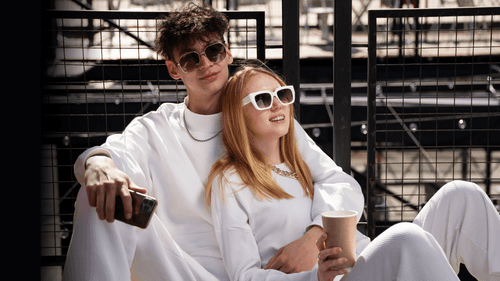 Boyfirend and girlfriend wearing white and sunglasses looking at something